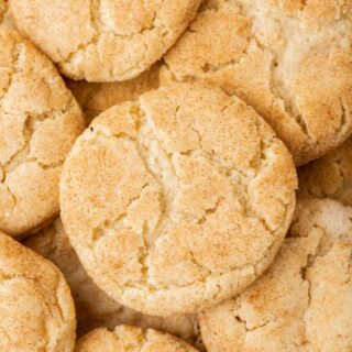 Closeup of a pile of gluten-free snickerdoodles with cracked tops and cinnamon sugar coating.
