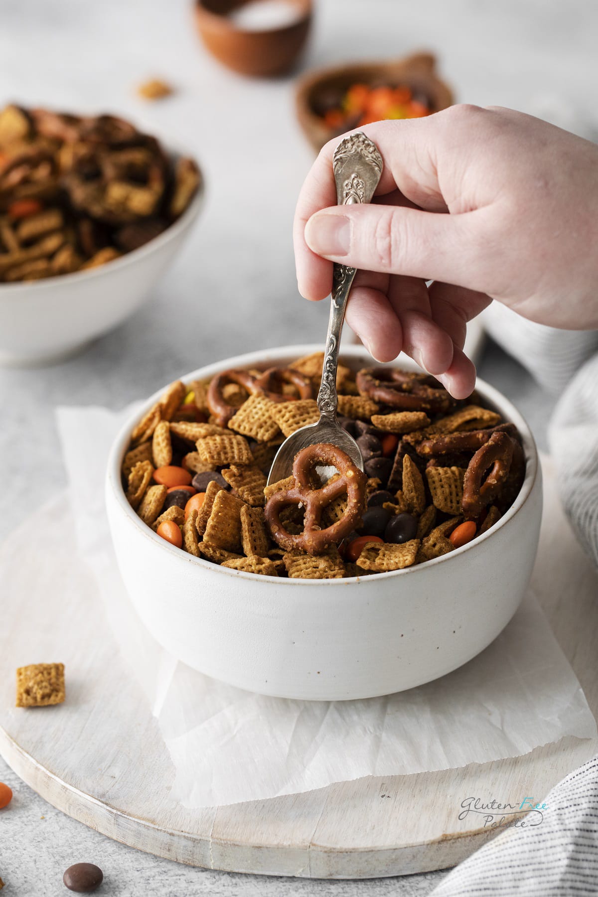 hand and spoon with gluten free chex mix