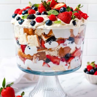 a gluten free trifle with layers of cake, whipped cream and berries