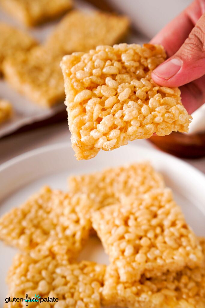 Gluten-free rice krispies treats being held by a hand.