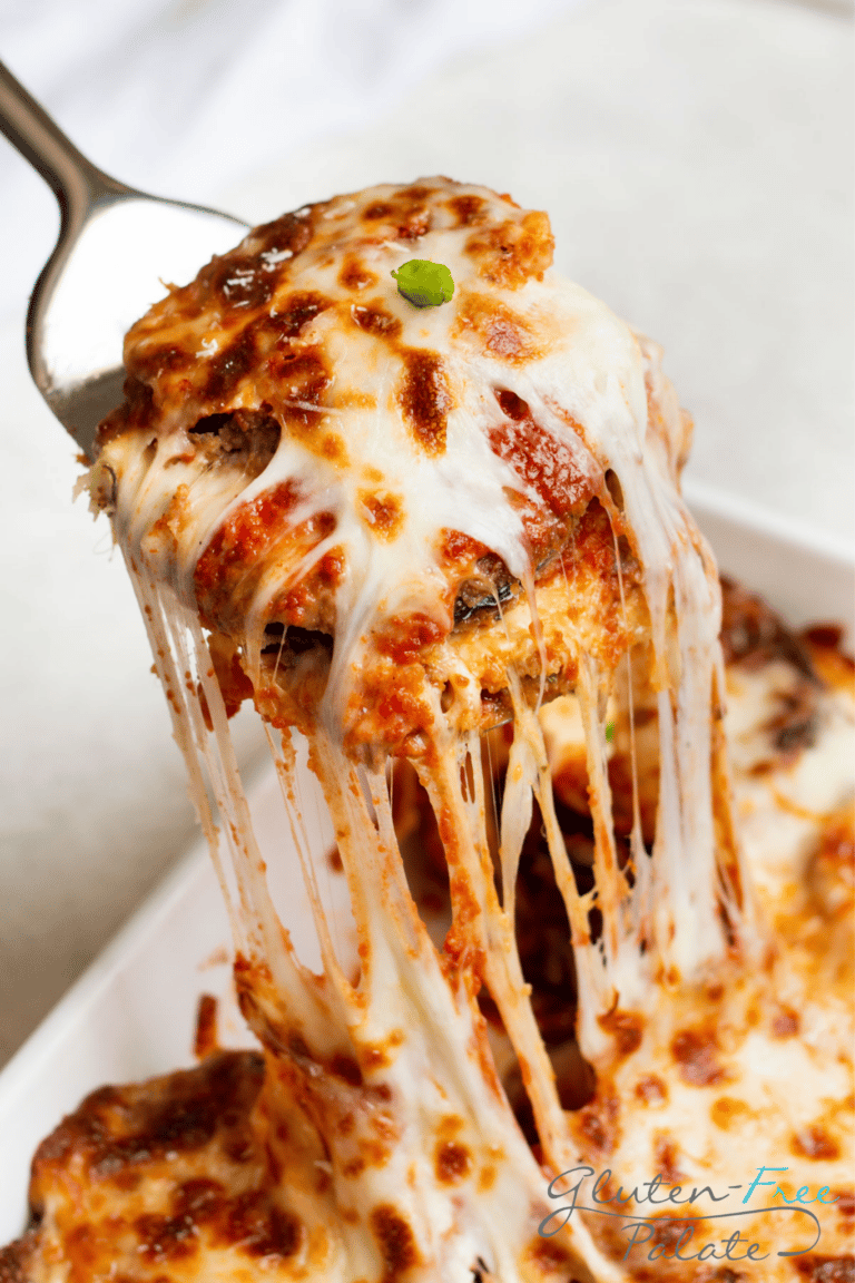 gluten-free eggplant parmesan being dished out of a white casserole dish