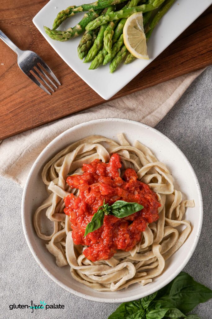 Gluten-free pasta in a bowl with red pasta sauce.