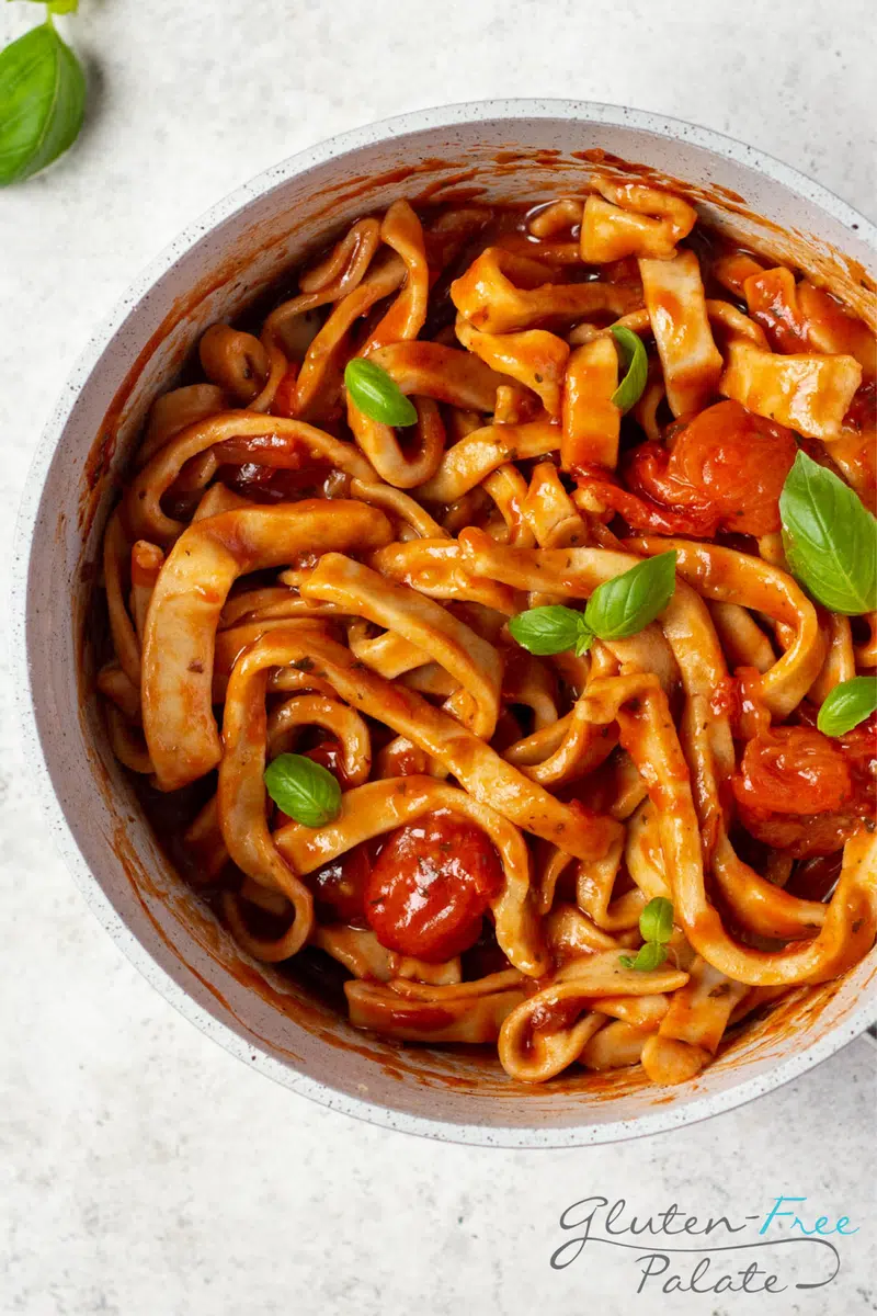 Gluten-free pasta recipe in a pot with sauce and basil