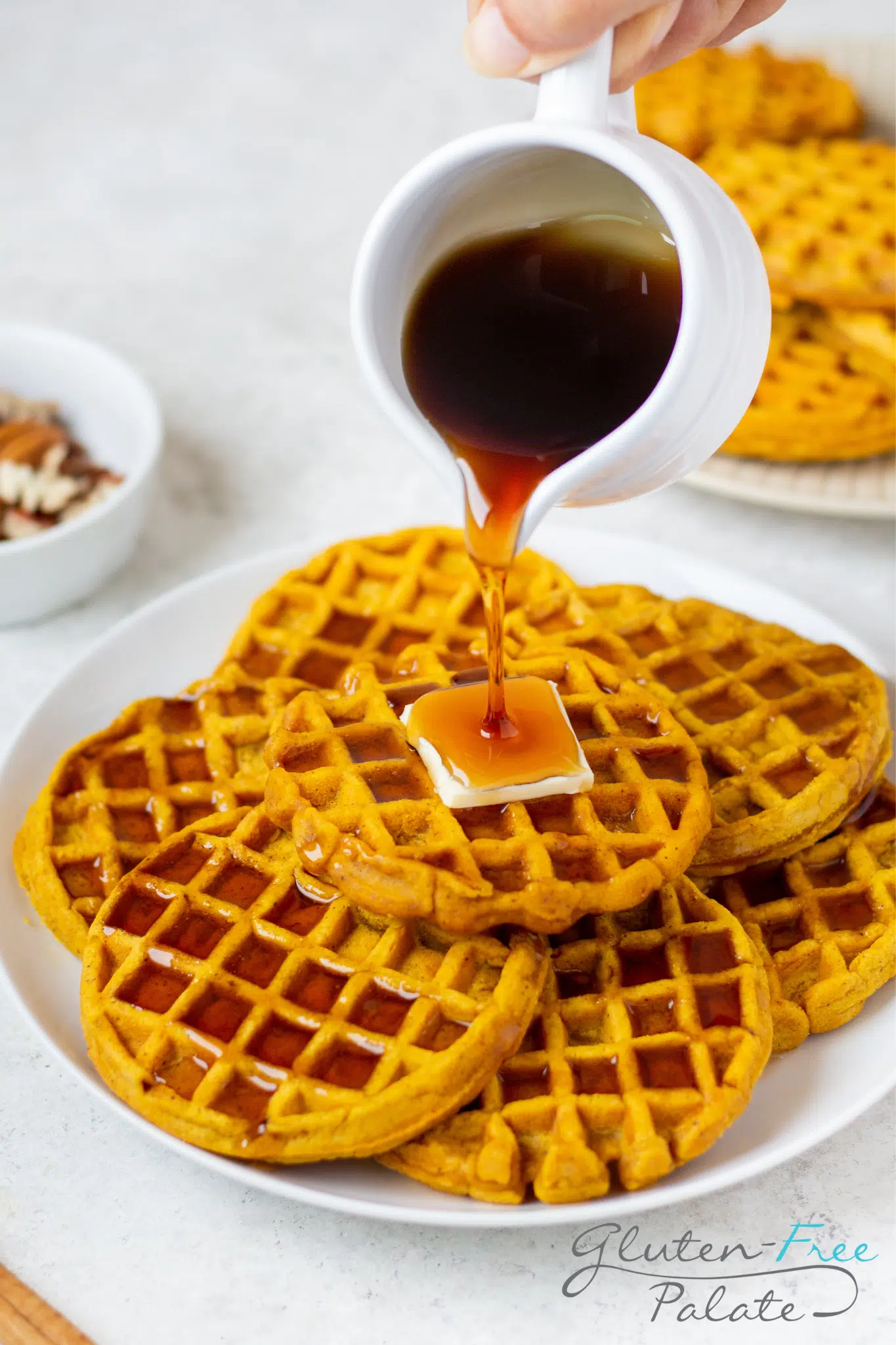 Gluten-Free Pumpkin Waffles with syrup being poured over.
