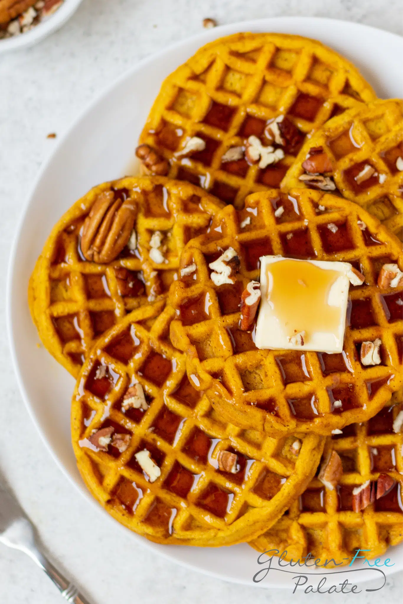 Gluten-Free Pumpkin Waffles with maple syrup, pecans and butter.