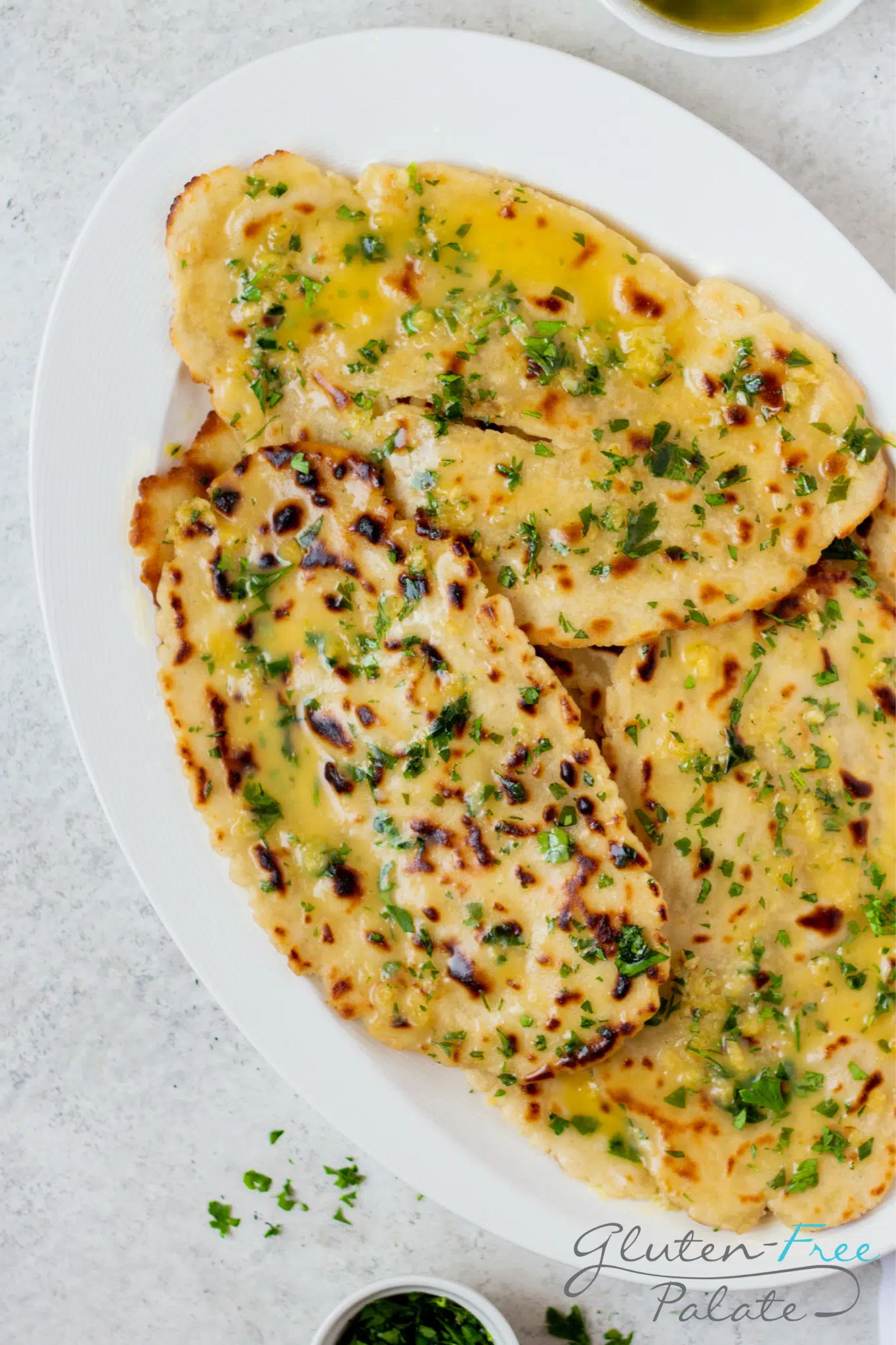 a white oval plate stacked with homemade gluten free naan