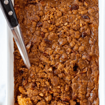 A dish of Gluten-Free Sweet Potato Casserole with a scoop.