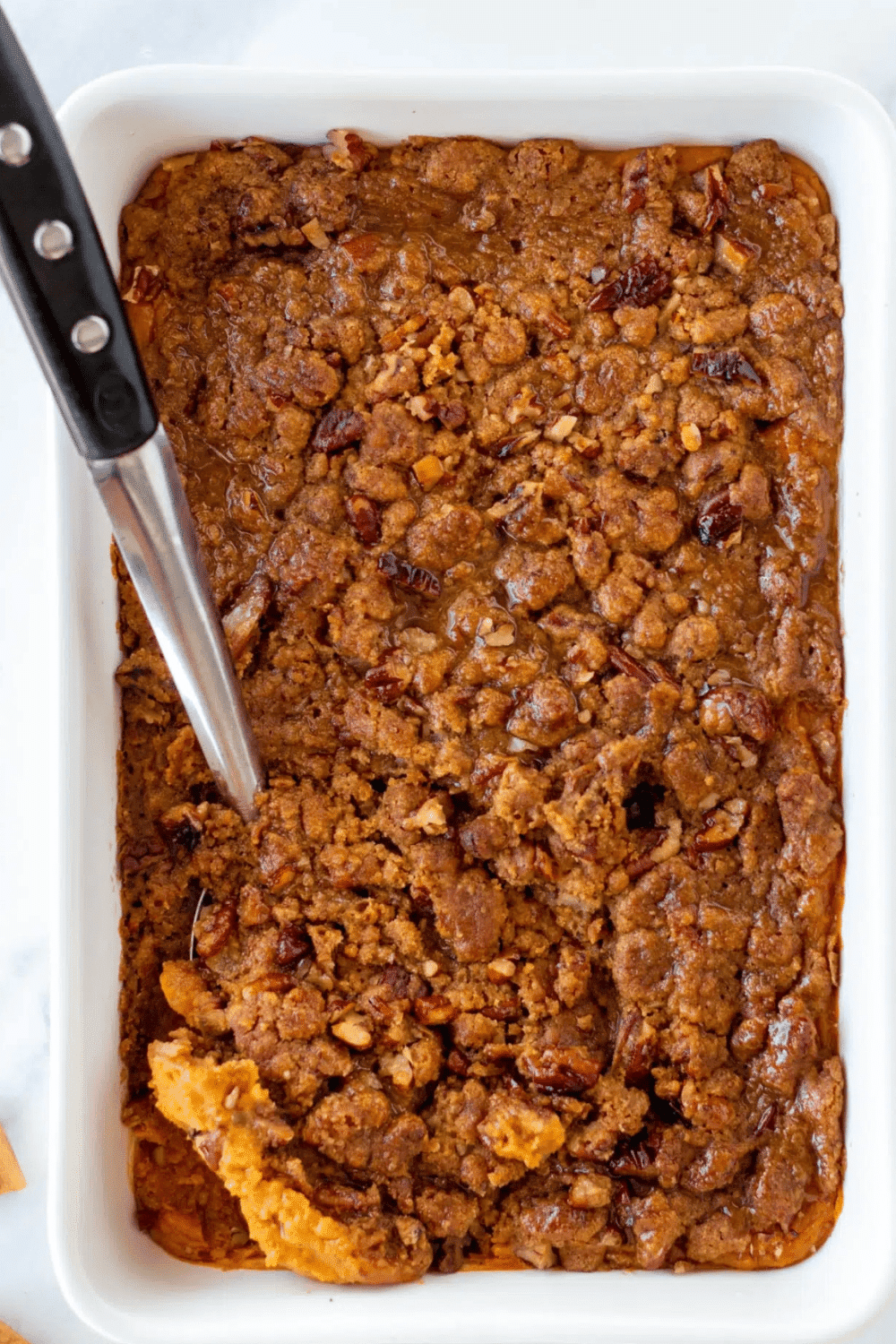 A dish of Gluten-Free Sweet Potato Casserole with a scoop.