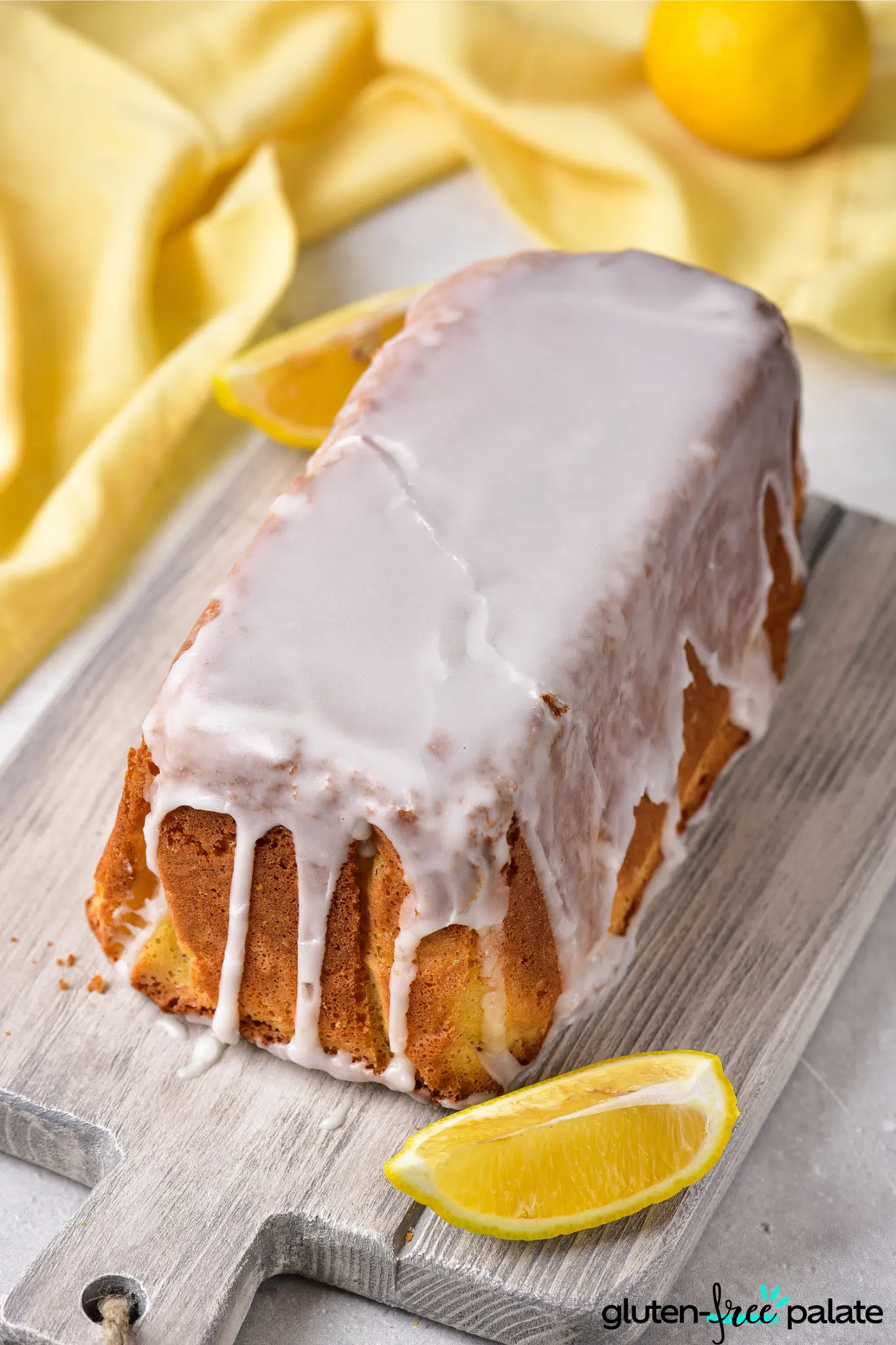 Gluten-free lemon drizzle cake on a board.