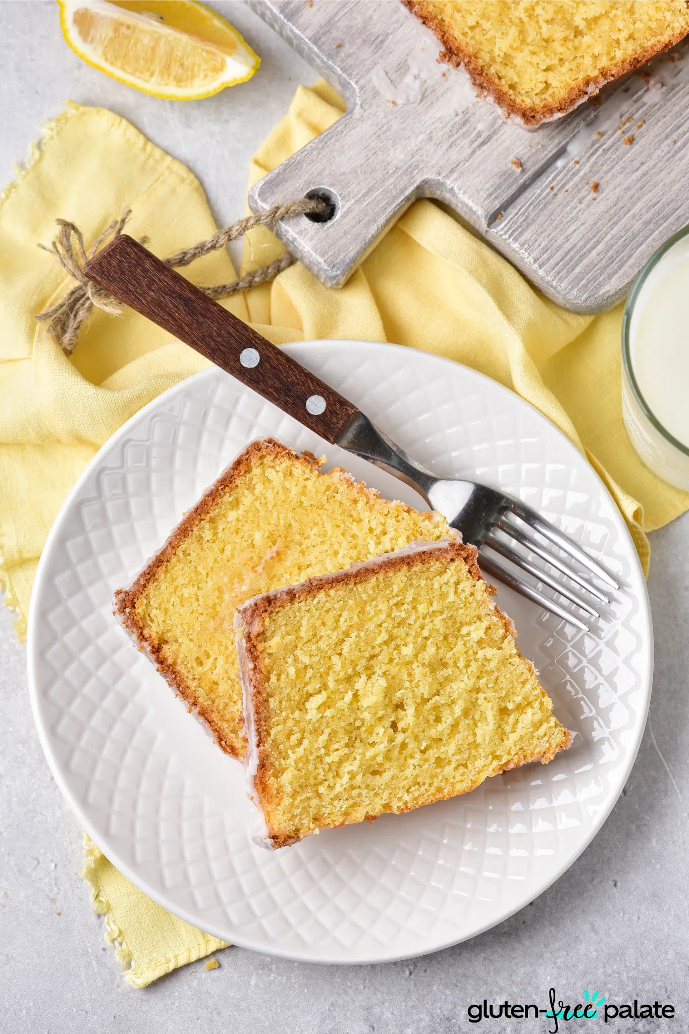 Gluten-free lemon drizzle cake on a white serving plate.
