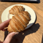 A hand holding a gluten-free croissant.