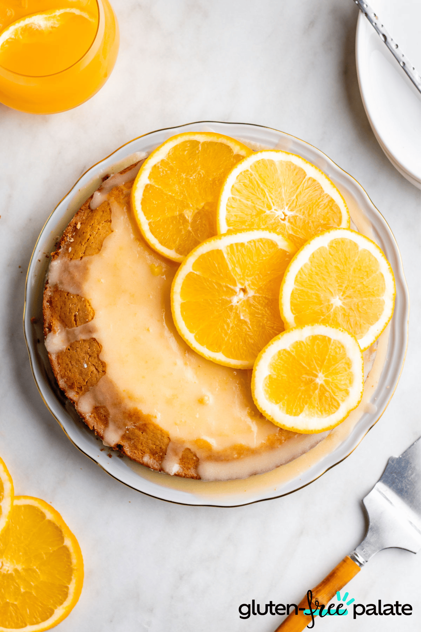 Gluten-Free Olive Oil Cake on a cake plate with orange slices