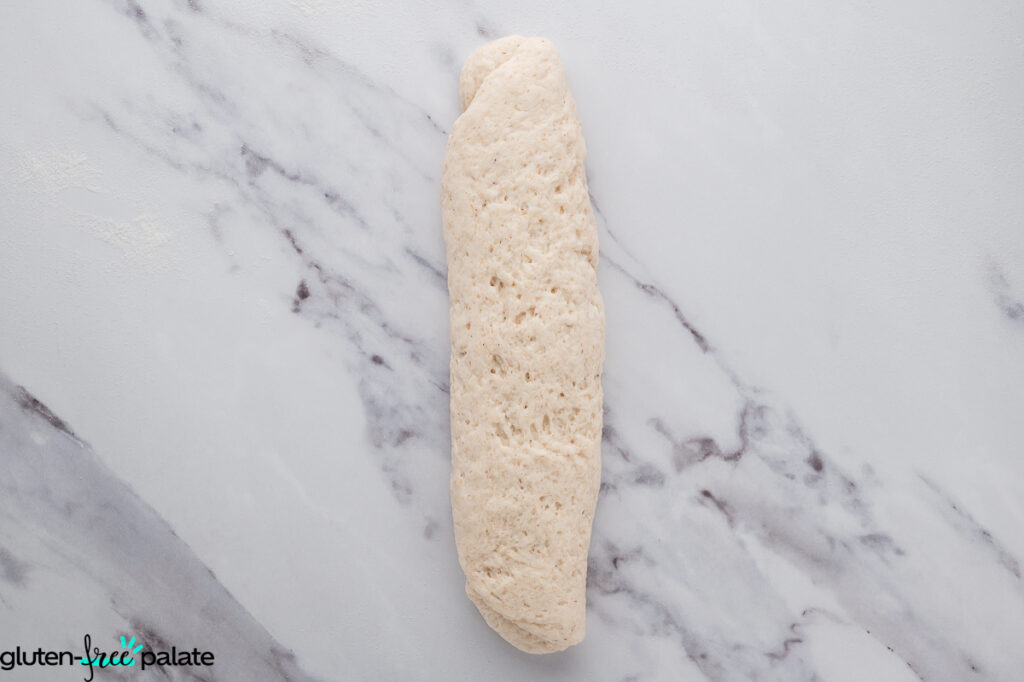 Dough rolled into a long baguette shape, ready for baking.