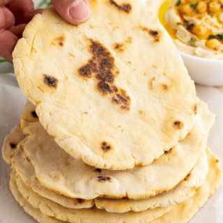A stack of Gluten-Free Pita Bread being held up