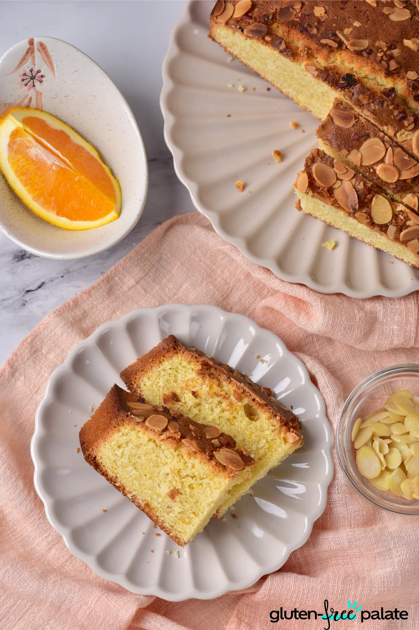 gluten-free almond cake on white cake plate with a side plate serving.