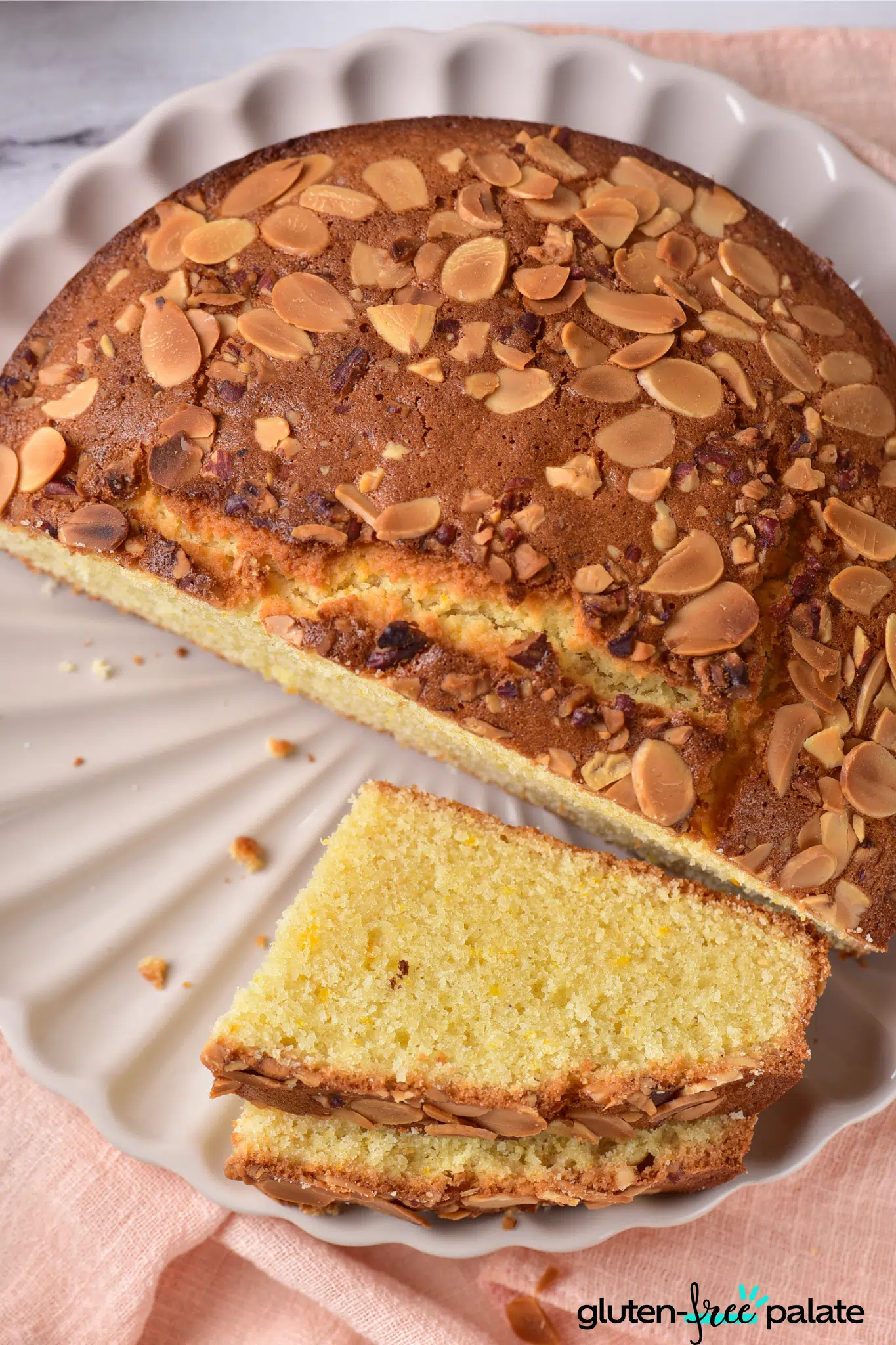 gluten-free almond cake on white cake plate.