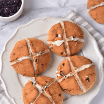 Gluten-free hot cross buns on a white plate.