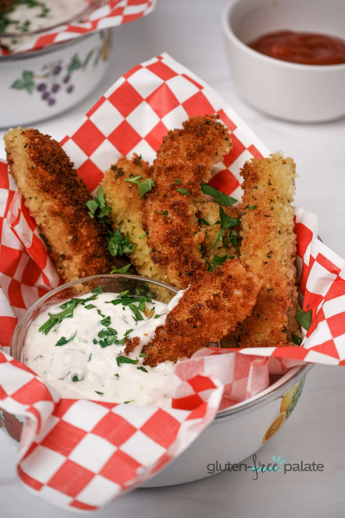 Gluten-Free Fish Sticks in a plate with red and white paper and dip