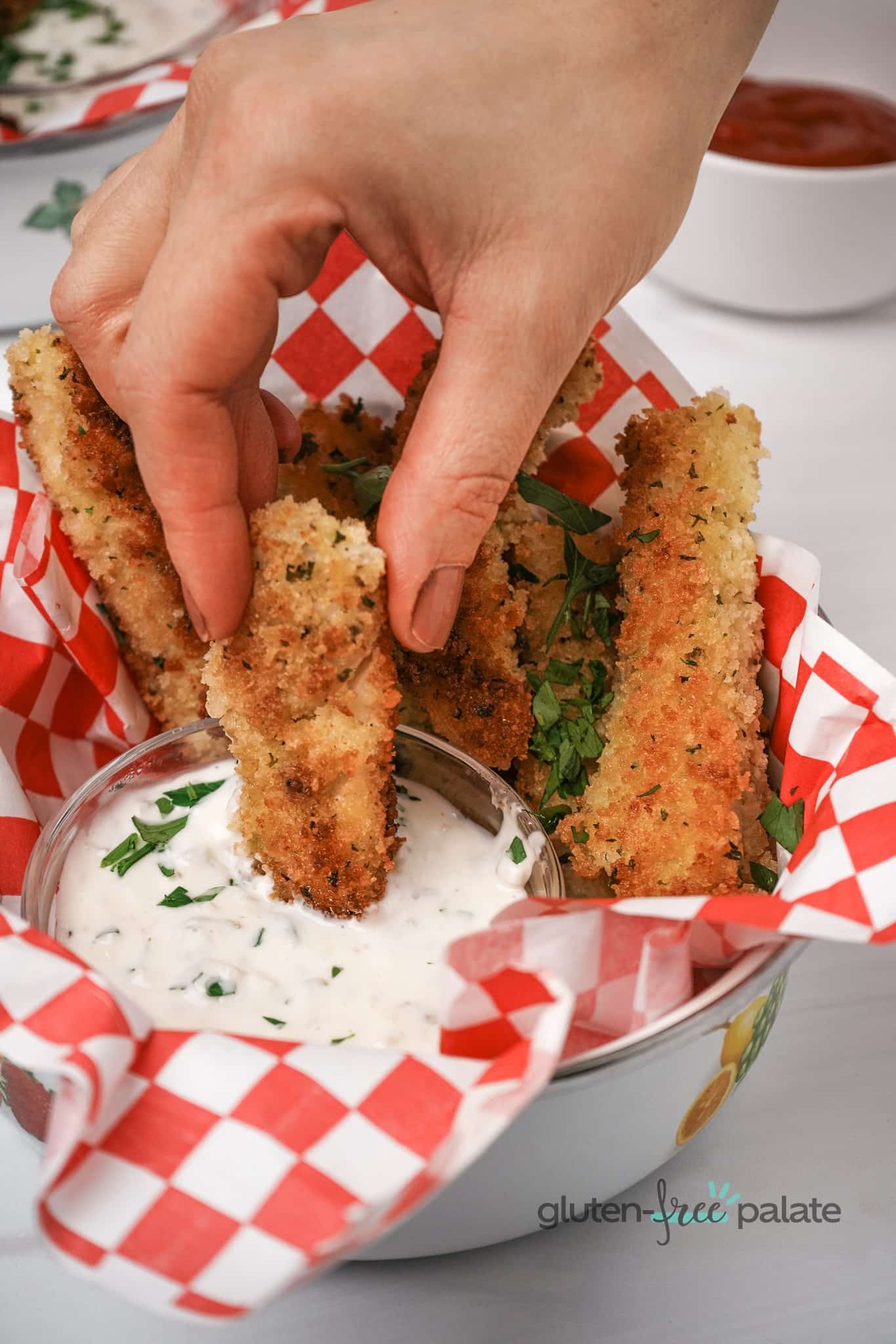 Gluten-Free Fish Sticks in a plate with red and white paper and dip