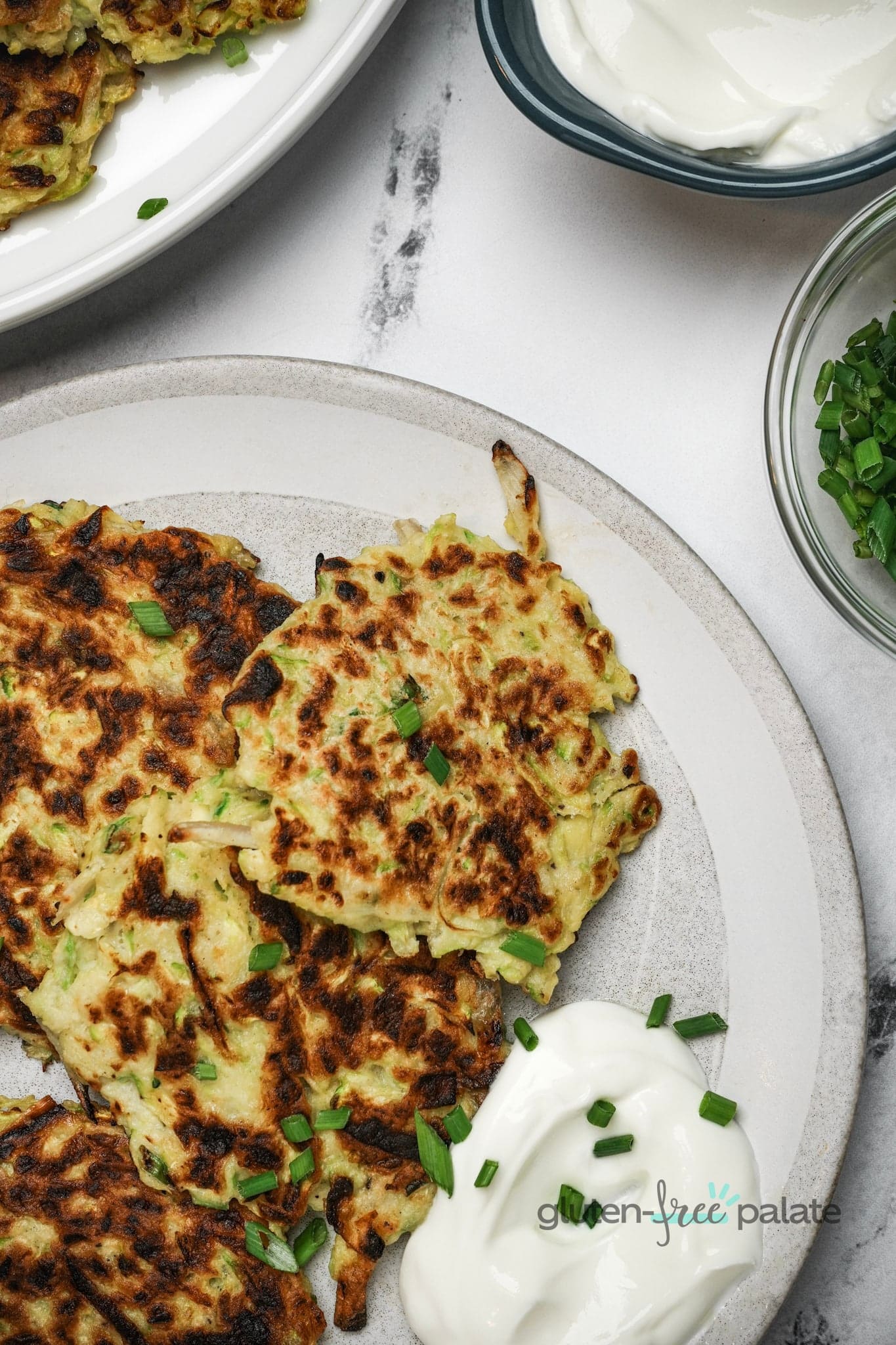 Gluten-free zucchini fritters on a white plate.