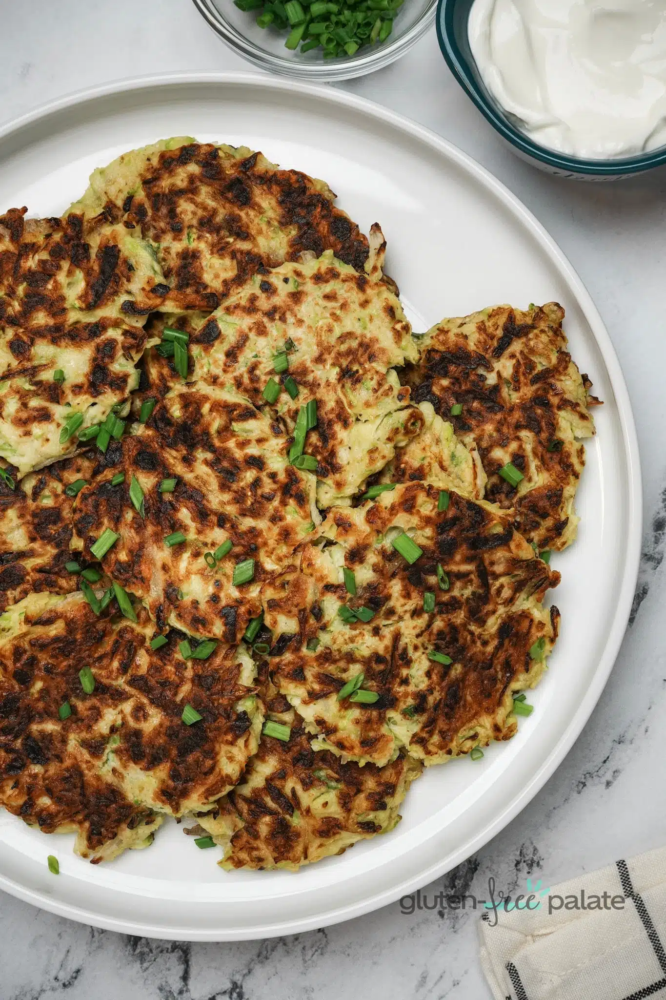 Gluten-free zucchini fritters on a white plate.