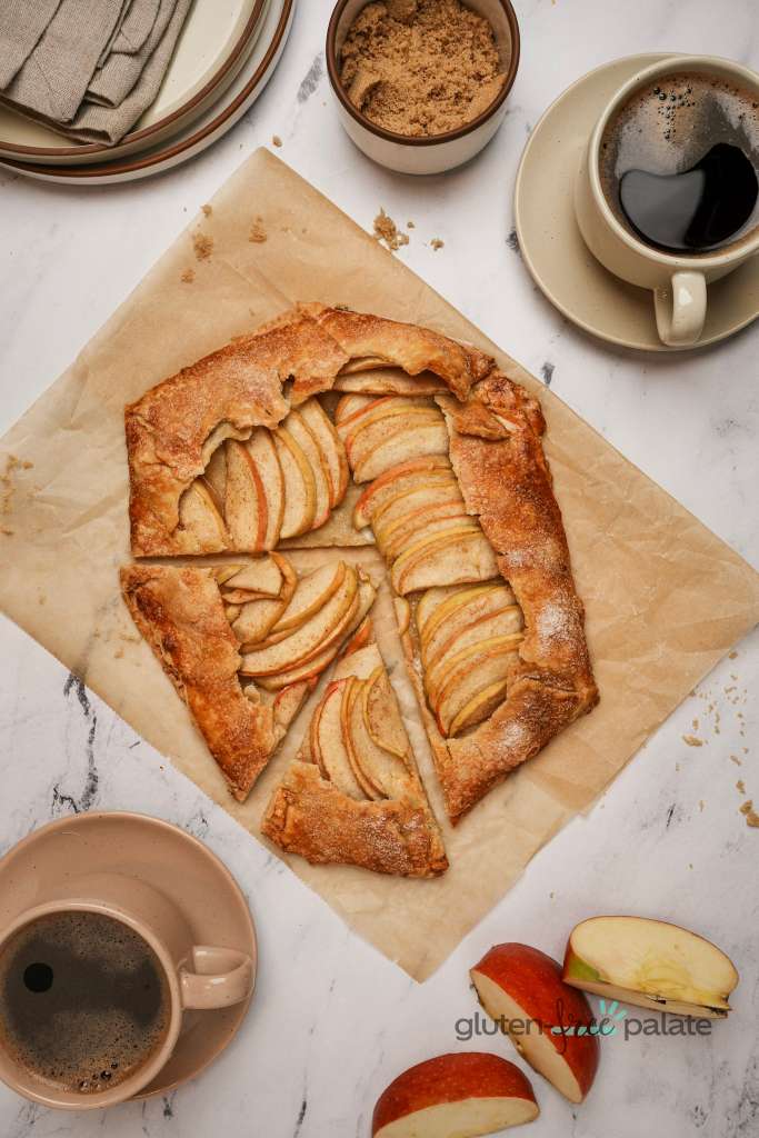 Gluten-free galette on brown baking paper with black coffee cups.