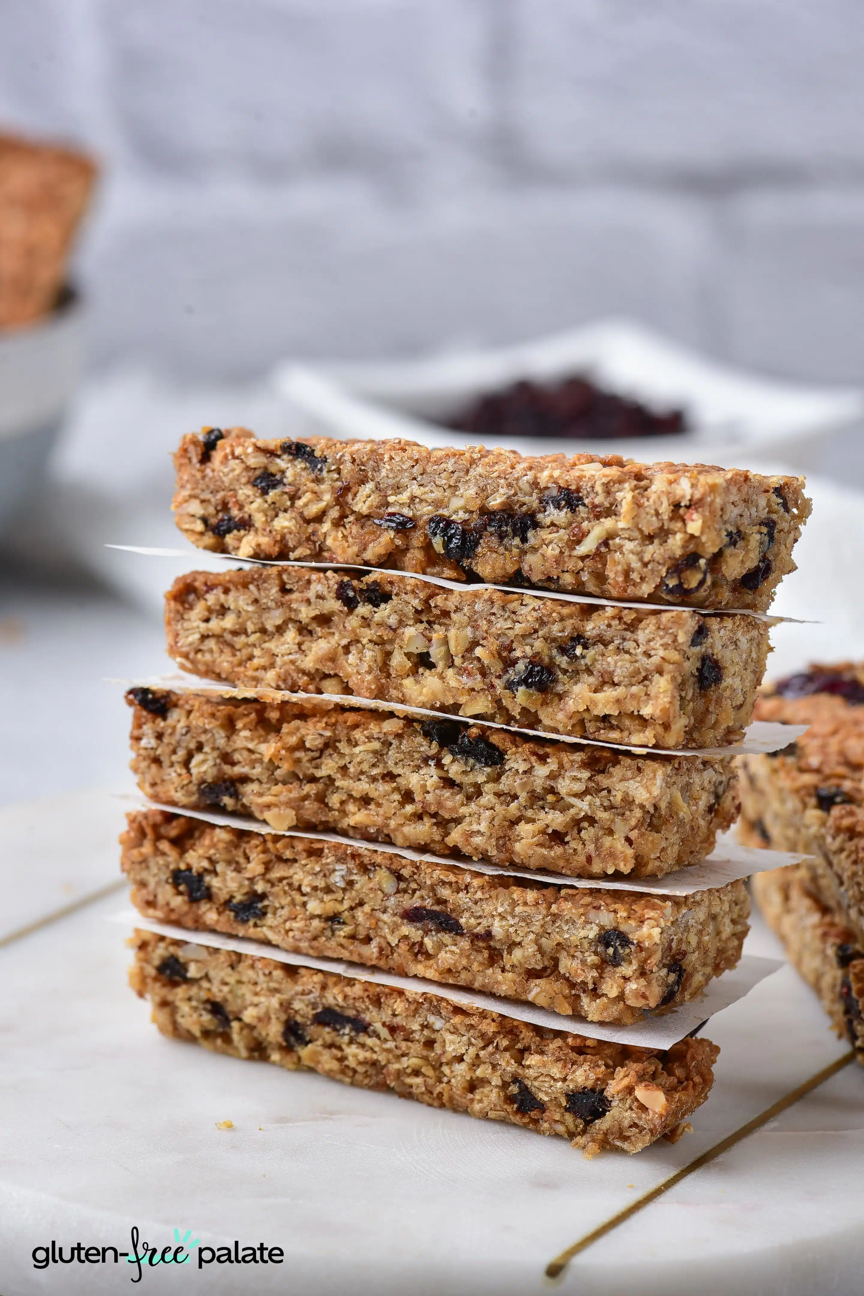Gluten-free granola bars stacked on top of one another with baking paper in between.