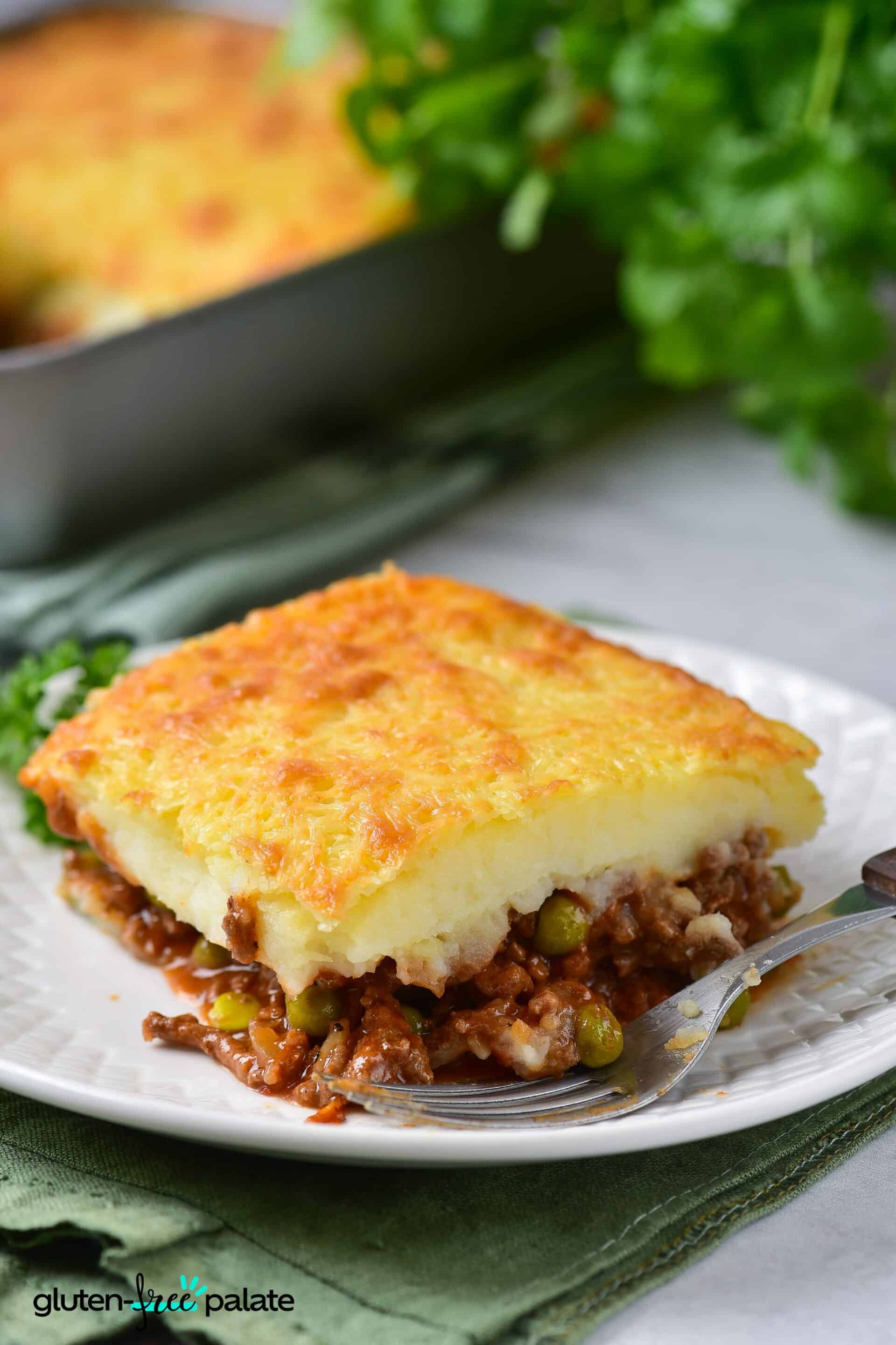 A slice of gluten-free shepherds pie on a white plate with a fork