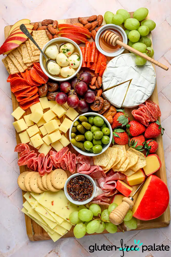 Gluten-free charcuterie board with gluten-free crackers, fruits, cheese and condiments