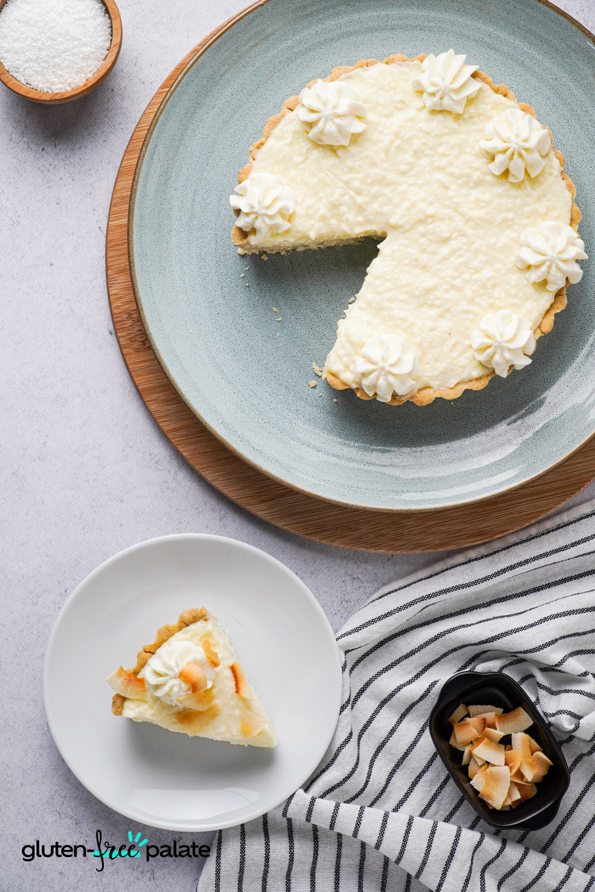Gluten-free coconut cream pie on a cake plate and another slice in a side plate.