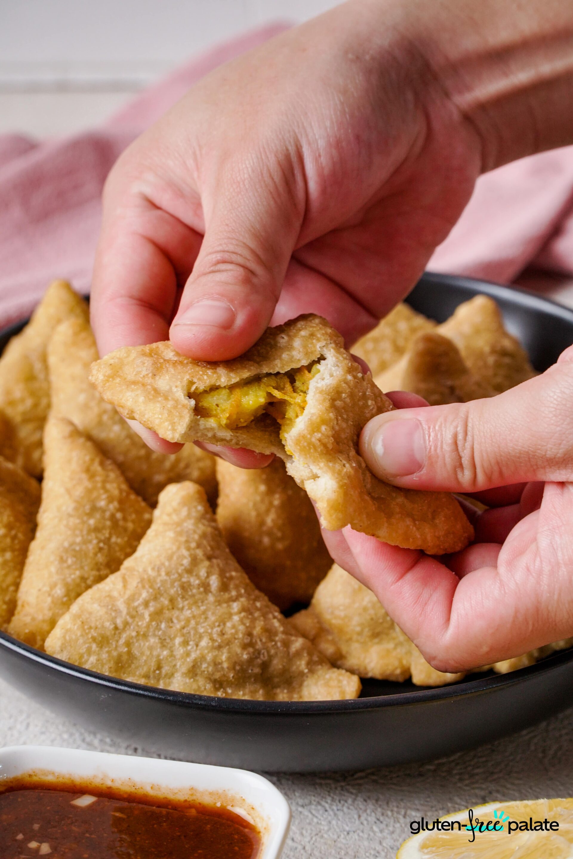 Gluten-free samosas being opened up to show the filling.