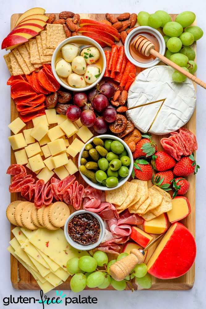 Gluten-free charcuterie board with gluten-free crackers, fruits, cheese and condiments