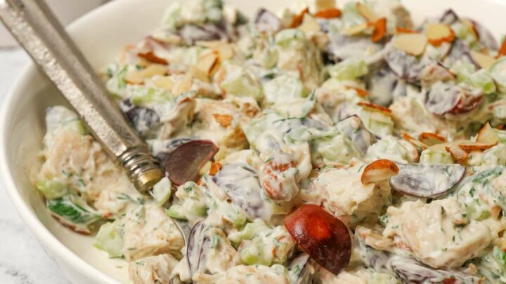 Gluten-free chicken salad in a white bowl with a serving spoon.