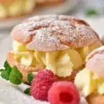 Gluten-Free Cream Puffs on a white plate with berries and mint.