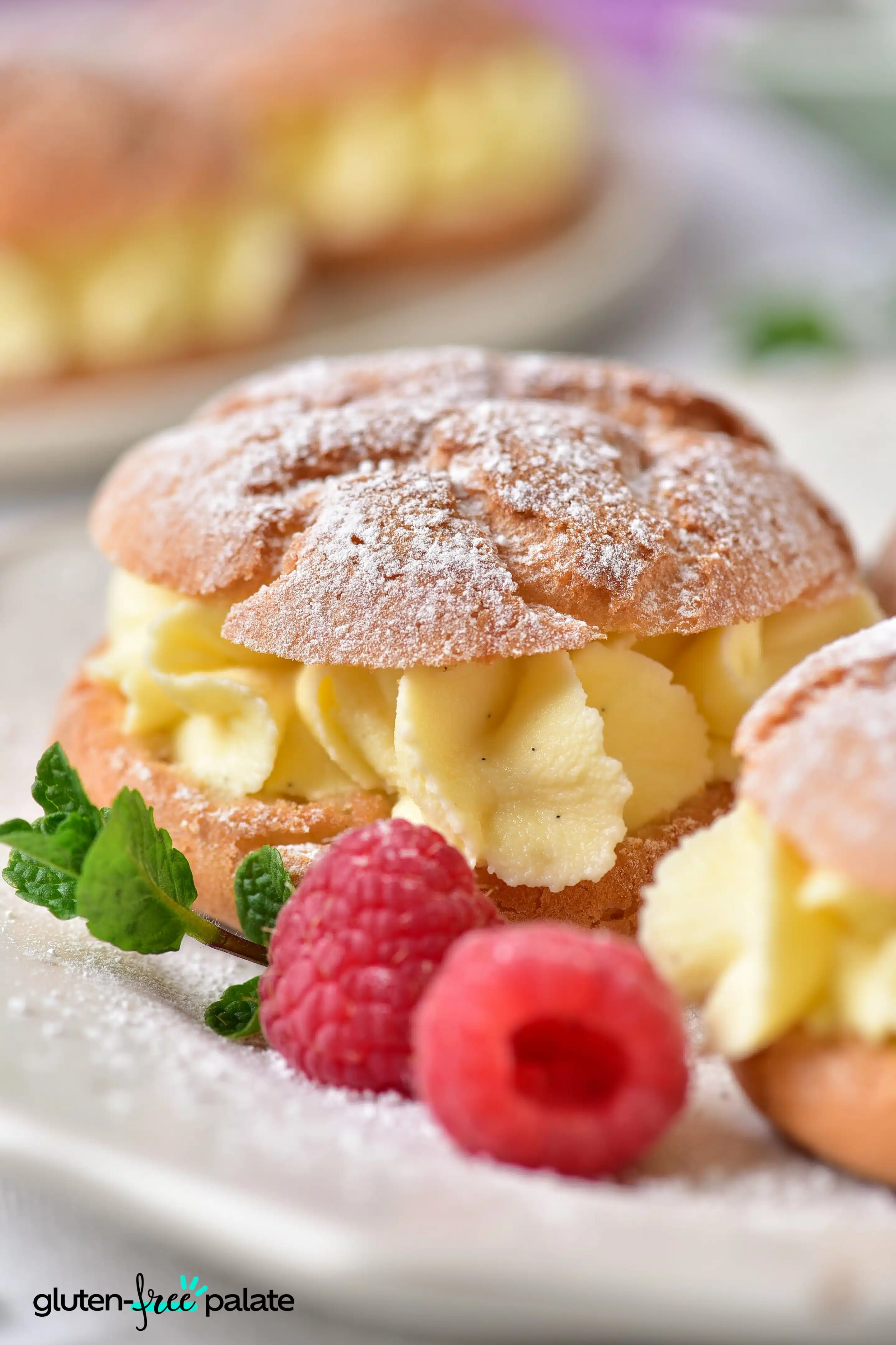 Gluten-Free Cream Puffs on a white plate with berries and mint.