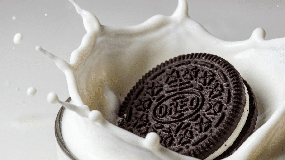 A gluten free Oreo falling into milk.