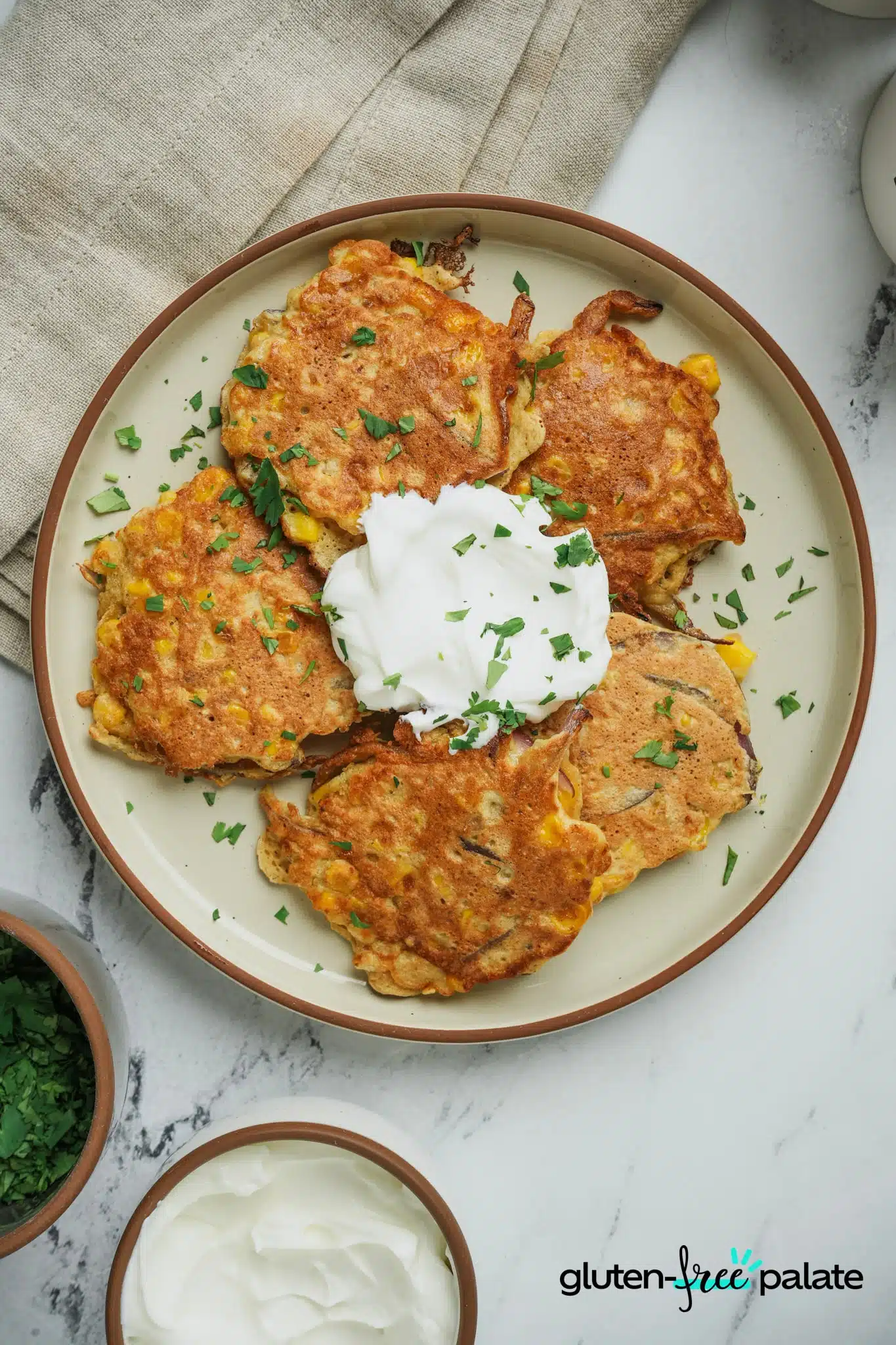 Gluten-free corn fritters on a plate with dipping sauce.