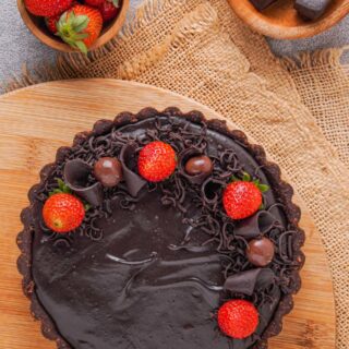 Gluten-free chocolate cheesecake with strawberries on top.