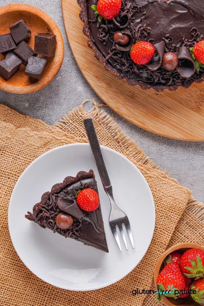 A slice of Gluten-free chocolate cheesecake in a white plate with a fork.