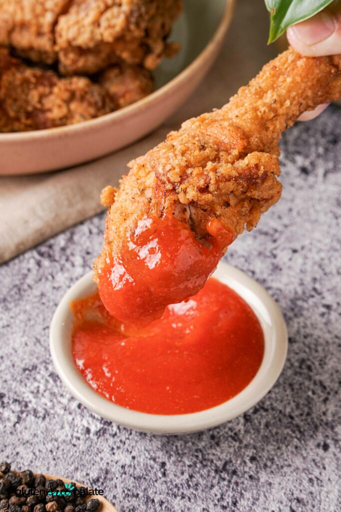 Gluten-Free Fried Chicken being dipped into a sauce.