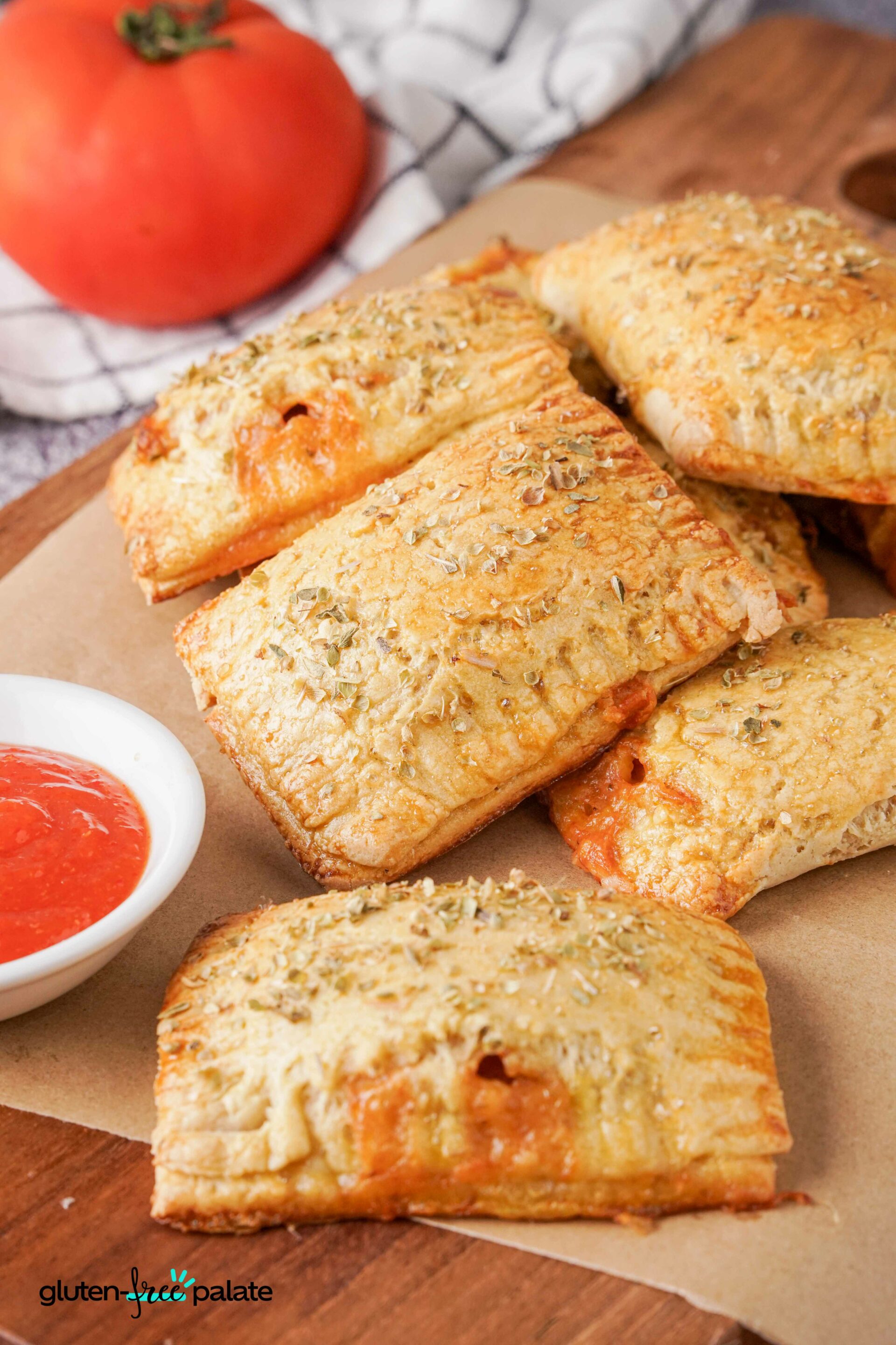 Gluten-Free Pizza rolls on a serving board with sauce.