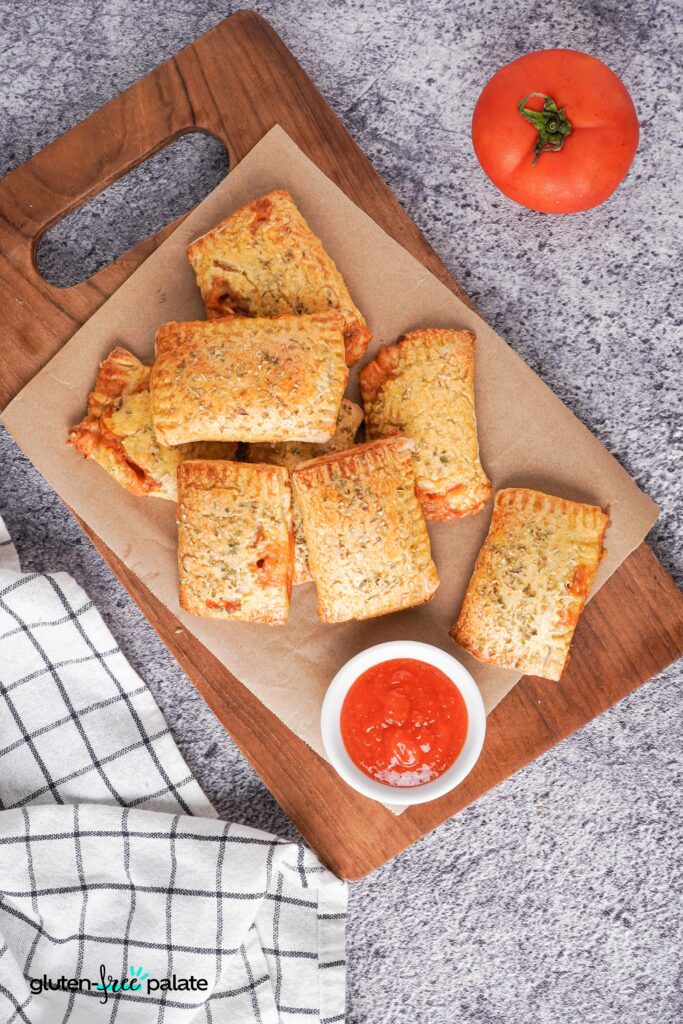 Gluten-Free Pizza rolls on a serving board with sauce.