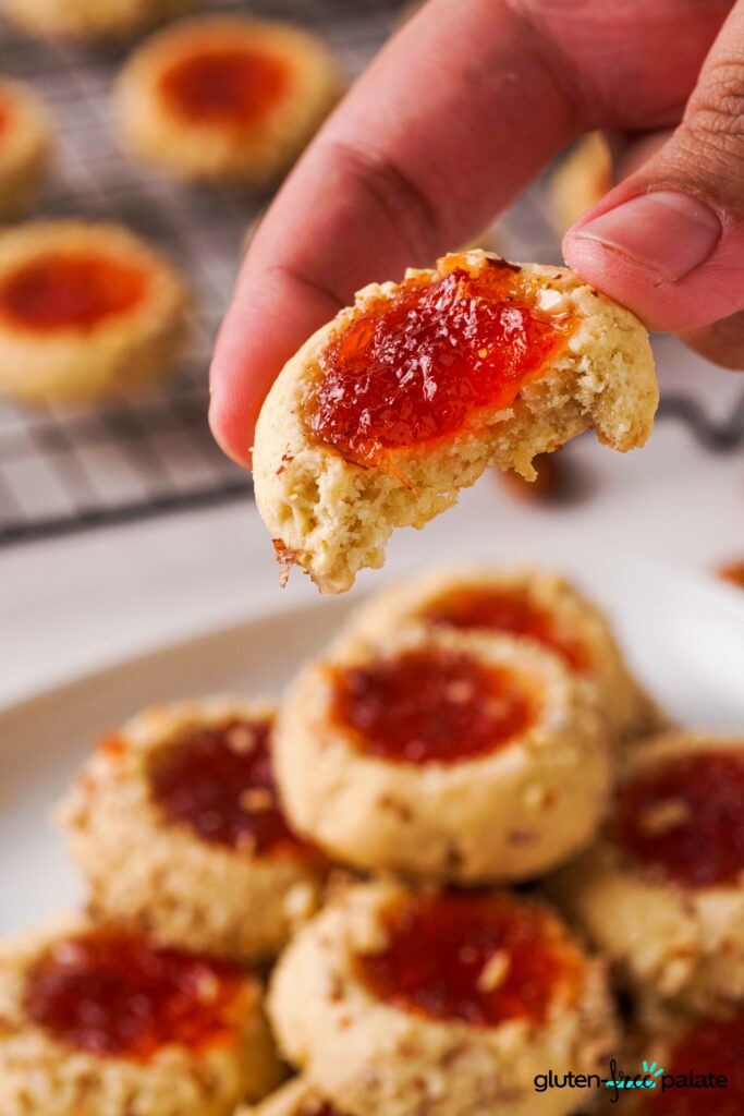 Gluten-free thumbprint cookies with a bite out of it showing the texture.