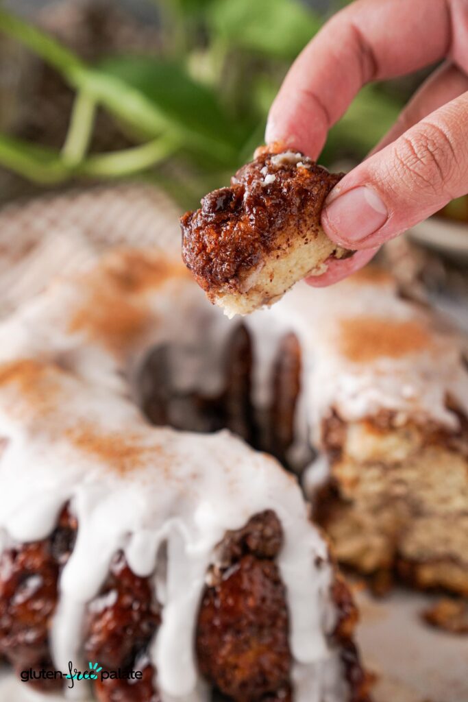 A piece of gluten-free monkey bread being held in a persons hand.