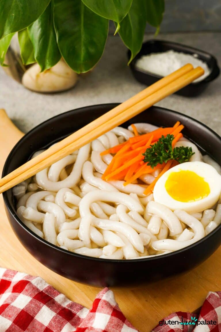 Gluten-Free Udon Noodles in a black bowl with chopsticks.