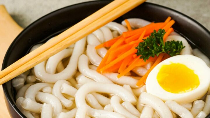 Gluten-Free Udon Noodles in a black bowl with chopsticks.
