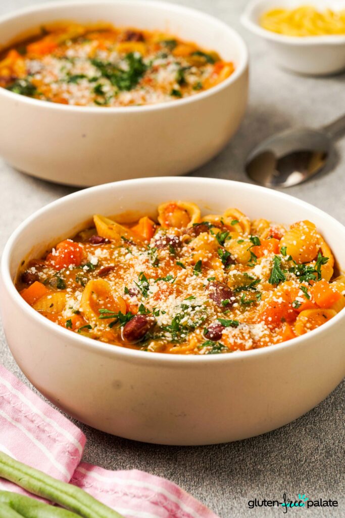 Gluten-Free Minestrone soup in bowls with garnish.