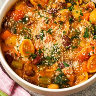 Gluten-Free Minestrone soup in bowls with garnish.