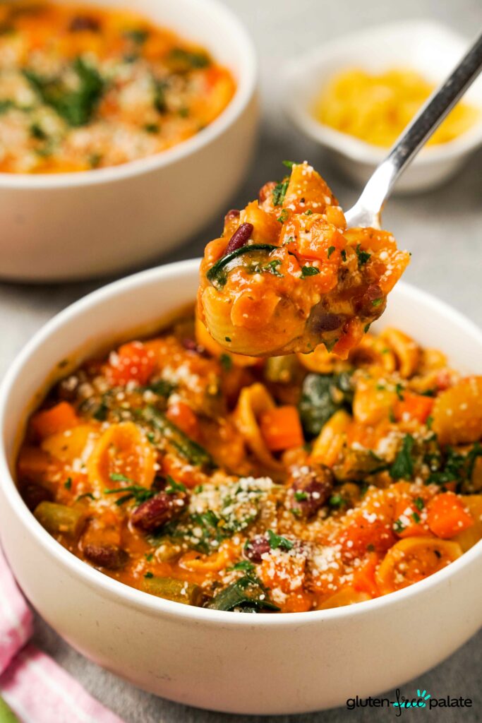Gluten-Free Minestrone soup in bowls with garnish.