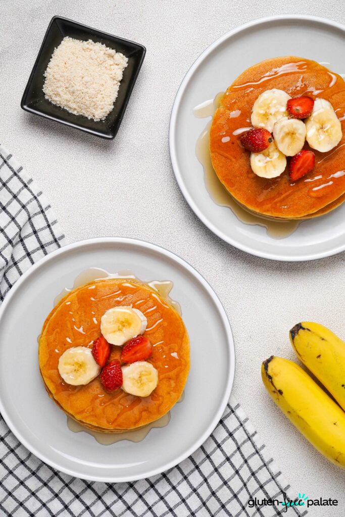 Gluten-Free Protein pancakes on a white plates with other ingredients.